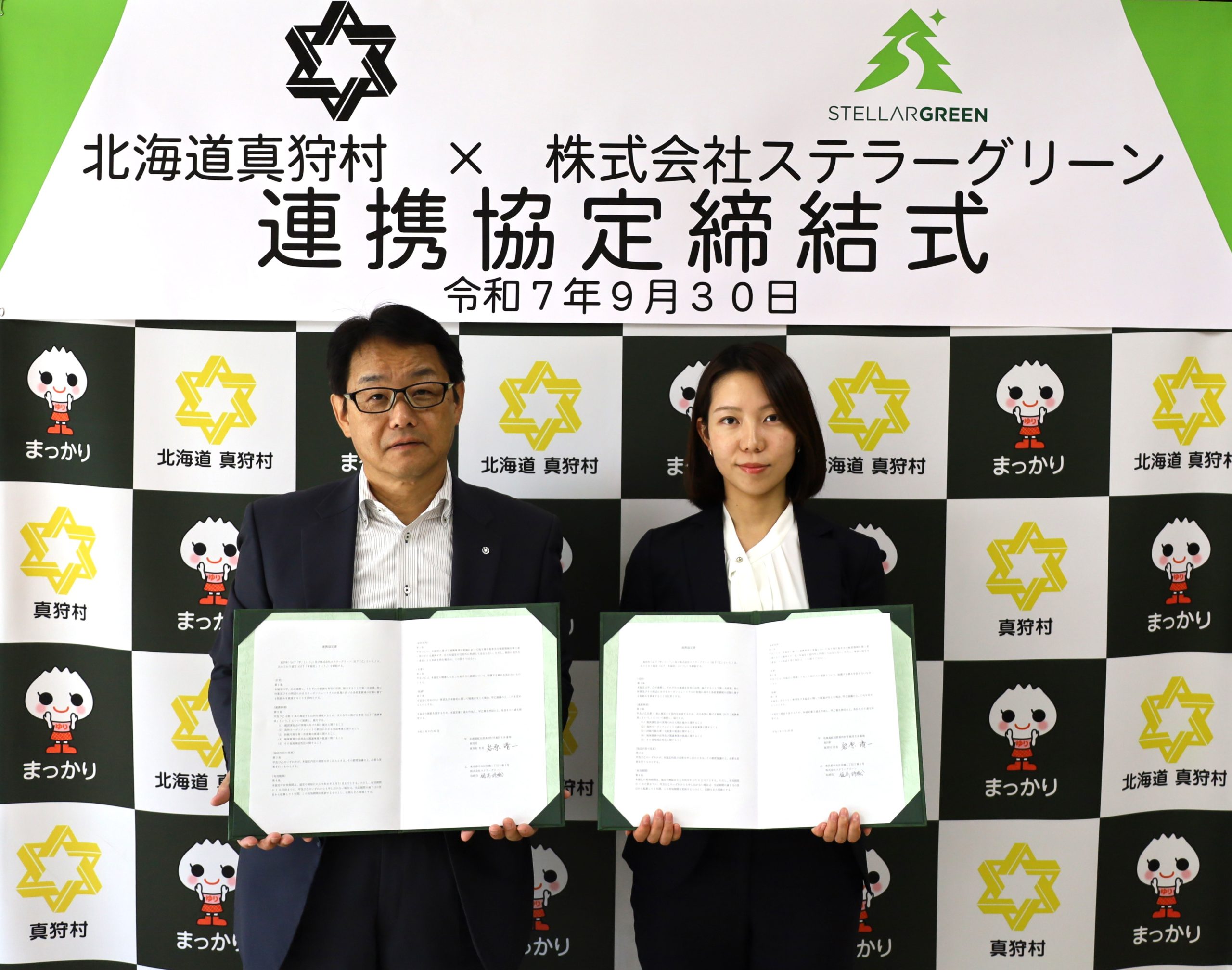 真狩村長 岩原清一とステラーグリーン樋高が協定書をそれぞれ持っている写真