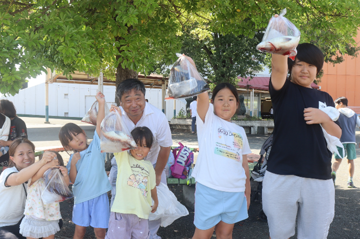 子供たちが魚をあげる姿